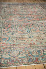 Distressed Lilihan carpet's ruby red field, sapphire blue palmette border, and fringe.