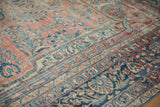 Distressed vintage Lilihan carpet with sapphire blue palmette border and ruby red floral field.