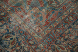 Lilihan carpet detail: distressed floral patterns in ruby red, sapphire blue, showing wear.