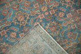 Close-up of distressed Hamadan rug revealing worn blue, red Herati pattern and visible woven back.