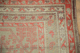 Corner detail of an antique Khotan rug showing low pile with even wear and geometric borders.