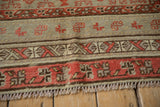 Antique Khotan rug's end border with geometric motifs in coral red, brown, and seafoam green.