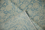 Folded vintage Distressed Mahal carpet revealing faded Herati design and machine-bound side.