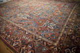 Corner of Vintage Baktiari carpet, intricate floral palmettes and germinating plant border in madder red and sapphire blue.