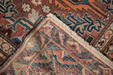 Vintage Baktiari rug corner detail showing hand-knotted foundation, cream fringe, and rich patterns.