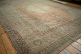 Angled view across the distressed low pile of a vintage Kayseri carpet in rust and ivory.