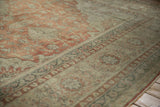 Time-softened rust and greige tones in the distressed floral border of a vintage Kayseri carpet.