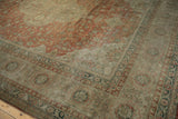 The corner of a distressed Kayseri carpet showing patina over scrolling rust-colored vines and beige borders.