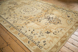A perspective view of the vintage Kars carpet's Rococo scrolls and time-softened texture.