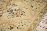 Low pile of the distressed Kars carpet showing charcoal floral scrolls and knot heads.