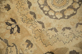 Close-up of stylized Rococo arabesques in charcoal and gold on the worn pile of a vintage Kars carpet.