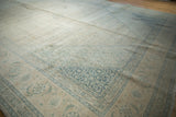 Distressed vintage Tabriz carpet corner showing Herati design in faded ivory and dusty blue.