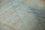 Distressed vintage Tabriz carpet: worn ivory and dusty blue Herati design motif, faint foundation.
