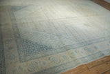Vintage distressed Tabriz carpet section with faded ivory and dusty blue Herati pattern, showing even wear.