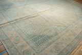 Distressed vintage Tabriz carpet corner with faded ivory, beige, and dusty teal Herati design.