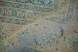 Worn pile of vintage distressed Tabriz carpet, in ivory, beige, and dusty blue foliate designs.