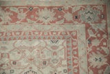 Serrated arabesques and pawn motifs on the corner of a distressed vintage Turkish carpet.