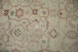 Close-up of serrated arabesques and floral motifs showing the distressed, low-pile texture.