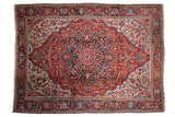 Vintage Persian Ahar carpet with an oversized navy blue medallion on a cherry red field.