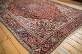 Intricate corner spandrel on a vintage Ahar carpet featuring serrated leaves in cherry red and navy.