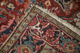 Folded corner detail of a vintage Ahar carpet highlighting the hand-knotted construction and fringe.