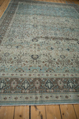 Distressed Persian Qom carpet end with machine binding and muted floral border.