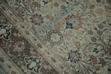 Faded aqua blue and coffee brown floral blossoms on a distressed vintage Qom rug.