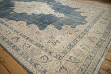 Distressed Sparta carpet corner detail with worn dusty blue field and ivory, pink palmette border.
