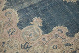 Distressed vintage Sparta rug detail: dusty cobalt blue field, pink palmette spandrel.