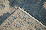 Distressed Sparta carpet corner with worn dusty cobalt blue field, patterned beige border, and fringe.