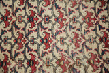 Close-up detail of vintage Baktiari carpet's brick red and navy floral bat motif.