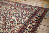 Vintage Baktiari carpet corner, red floral bat motif field, pomegranate and leaf border.
