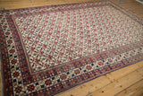 Vintage Baktiari carpet corner showing pomegranate border and floral bat field motifs.