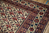Vintage Baktiari rug corner detail: brick red floral bat motif, cobalt border.