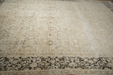Distressed field of vintage Meshed carpet with faded sandalwood and charcoal floral motifs.