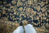 Worn pile of a vintage Lilihan carpet showing sand-colored floral arabesques on a navy field.