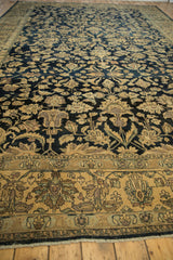 Low perspective of a distressed Lilihan carpet's worn pile, showing sand-colored palmettes on a navy field.