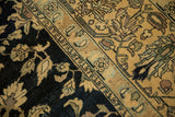 Even wear on the hand-knotted pile of a vintage Lilihan carpet's navy and sand border.