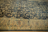 Angled view of a vintage Lilihan rug's distressed pile, highlighting its navy abrashes and sand florals.