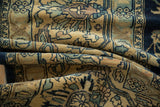 Folds on a vintage Lilihan carpet showing worn texture and blue arabesques on a sand field.