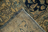 Corner of a distressed Lilihan carpet folded to show the hand-knotted weave and secured side cord.