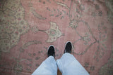 Distressed pink Turkish Sparta carpet with faded floral motifs and textured wear underfoot.