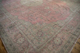 Distressed pink Sparta carpet corner highlighting curvilinear spandrel, vines, and faded floral motifs.