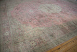 Faded pink field of a distressed vintage Sparta rug with silver vines and ornate corner spandrel.