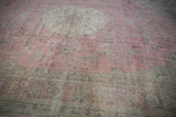 Distressed pink and dusty rose field with an ornate border of oxidized silver and charcoal patterns.