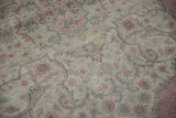 Distressed pile texture of a vintage Sparta carpet with faded pink and charcoal floral motifs.
