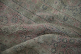 Distressed dusty rose and charcoal curvilinear patterns on a vintage Turkish Sparta carpet.