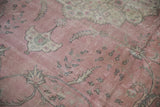 Vintage distressed Sparta carpet detail: dusty rose field with time-softened palmettes and subtle charcoal blossoms.