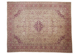 Distressed Oushak carpet featuring an ivory field with pale dusty raspberry medallion and vinery.