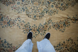 Vintage Kerman carpet's soft pile texture, ivory field with sky blue and apricot blossoms underfoot.